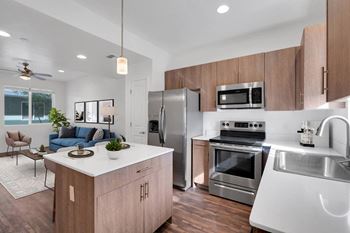 A modern kitchen with a white island and stainless steel appliances.
